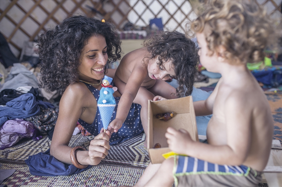 Mother daughter and a friend playing in a Yurt house, 