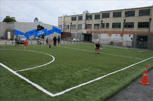 Football in the gap - local kids enjoy a new man-made soccer field near the city centre in the gap where a building used to stand between a pile of rubble from ruined shops and a cordoned off building with a questionable future.