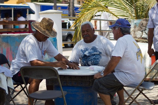 While some of the fishermans prepare the nets for the next day, others play dominoes to pass the time.