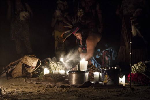 Lourdes, a woman from the “otomí” ethnic group lights the candles in the altar, setting the start of the ceremony. Around her, there are flowers as part of the offerings, water and small pieces of ‘peyote’, a cactus conceived as sacred medicine for some tribes in Mexico and North America -they will be distributed through out the night-, and other symbolic elements.