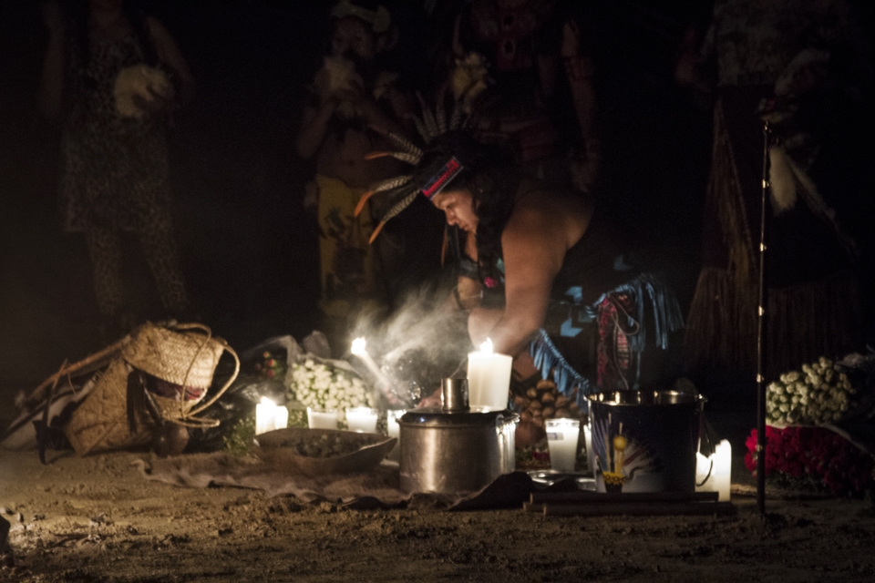 Lourdes, a woman from the “otomí” ethnic group lights the candles in the altar, setting the start of the ceremony. Around her, there are flowers as part of the offerings, water and small pieces of ‘peyote’, a cactus conceived as sacred medicine for some tribes in Mexico and North America -they will be distributed through out the night-, and other symbolic elements.