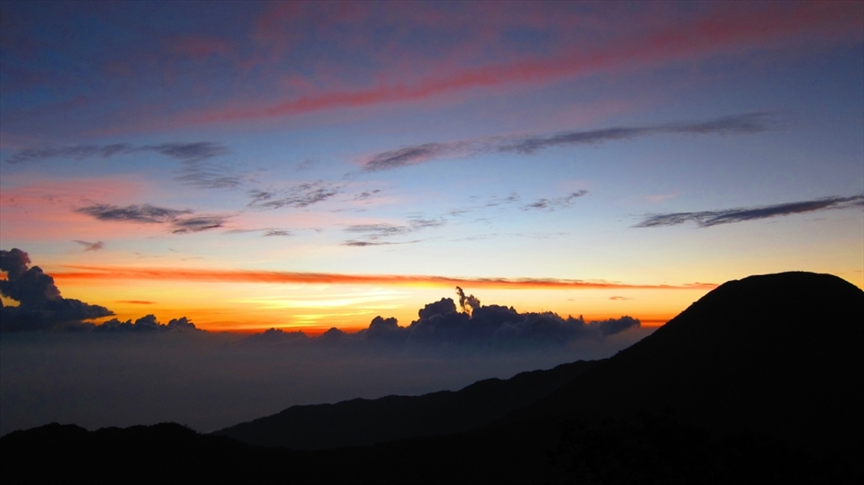 The sunset view from the peak of Mount Gede (2,958 meters). The wind had blown rather harshly this time around, yet along with it we have to walk across the trail provided to where we are going to camp and wait for the supermoon. Also shown in this photo is the peak of Mount Pangrango (3,019 meters), a sister mountain to Mount Gede. It was said that it would only take 3 hours to walk peak to peak, but we decided not to because my crews said the scenery from there is dissapointing.