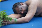 Hindu man having breather during ritual rolling for the Thimithi festival, the practice of rolling around the  sri Mariamman  temple can last all day for the men .The neem leaves are to ward off evil: by andrewnomad, Views[972]