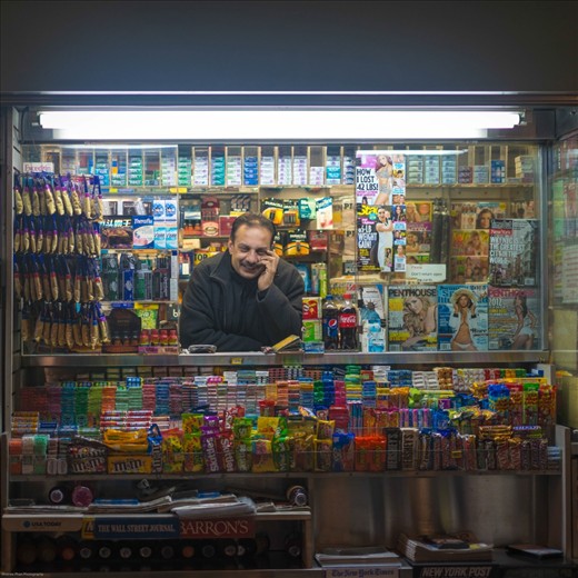 A man in his little booth, so full of colour and life, matching the smile on his face.