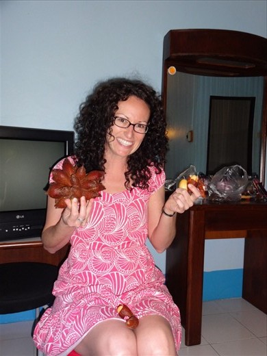 Jennifer is holding a rambutan fruit.  Its dark red and prickly on the outside.  Peel to eat.....