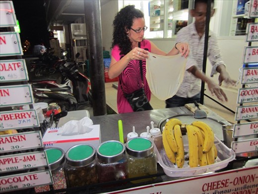 decided to get a banana pancake on our walk home from the bar.  then jen decided she wanted to learn how to make it so she just jumped back there. poor guy didn't know what to make of it.