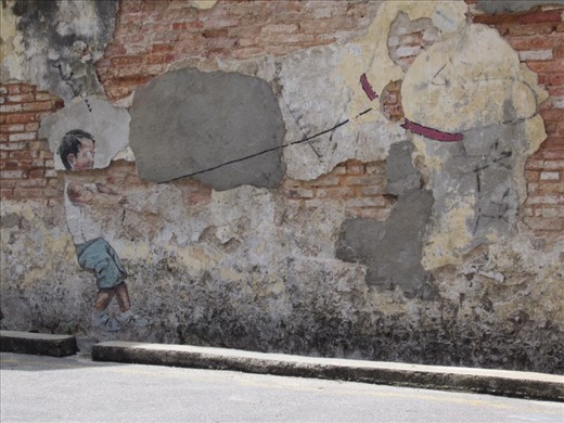 This one has been vandalized slightly.  On the other end of the boy's leash is a drawing of a 