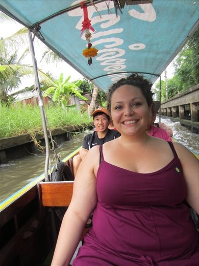 On a boat.  On our way to the floating market.