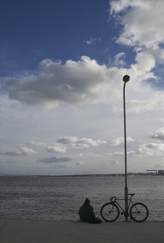 They are in a hurry. But still is this quickened city, they are some, who still search the opportunity, which Lisbon gives them - the opportunity to fly and to be free. In this idyllic city, not everyone is happy, but how could they? It gives me not only the great feeling, but the nostalgia, too. It makes me wanting to just stand there and stare at the beautiful sea. It makes me wanting to read, to create, to photograph, to be part of it, no matter in what way. And then I see this person. I see him standing there, being all alone. With his bicycle. Reading, being completely fine. Because he is part of Lisbon. 