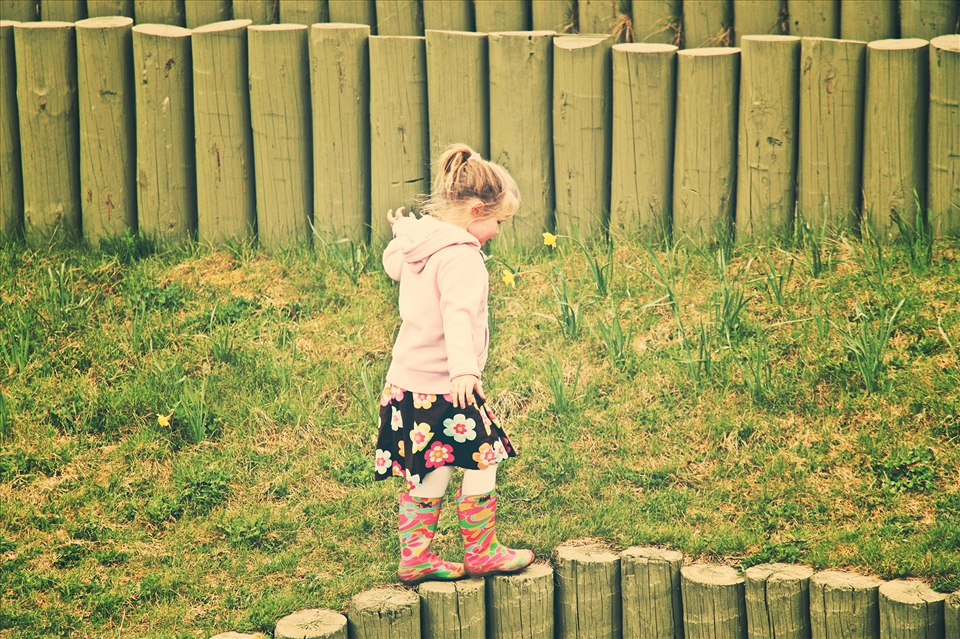 A cute little girl was playing on a small fence at Toronto Zoo. Her mother was calling her, but she was so lost in her childhood dreams.
