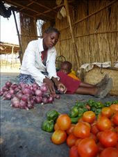 Mozambique has huge tracts of fertile, arable land, but lack of infrastructure and inputs, plus the ongoing recovery from a brutal civil war, mean that many people still lack access to adequate food. Eliza buys vegetables from a middleman and resells produce at the local market. Her son Edson huddles close to her side.: by angelluminate, Views[763]
