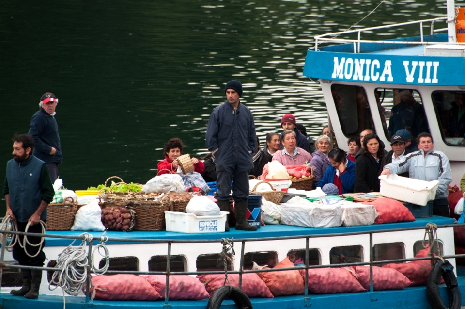THE ARRIVAL.
Every day, early in the morning, dozens of fishermen and small farmers navigate through the Tenglo watercourse up to Angelmó, one of the most typical places in Puerto Montt (Chile), to sell vegetables, meat and seafood flown in from nearby islands. In 1926, this fishing village was immortalized by the chilean painter Arturo Pacheco Altamirano and since then, it became a point of admiration for poets, painters and tourists around the world. But today there is little left of what once was: the sails of the boats were replaced by engines and oars, and the earthquake of 1960 profoundly affected the environment. And after the red tide that hit Angelmó 2005, the place was left dying. However, little by little, the place has come back to life and has been named as 
