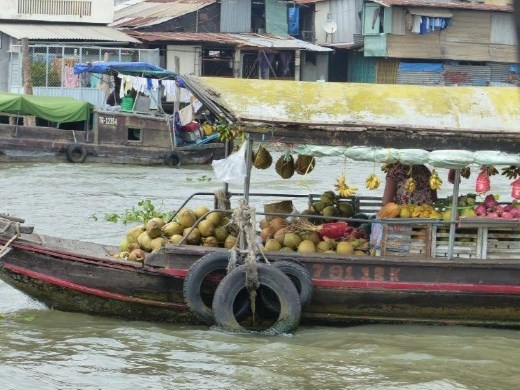 Fruit boat anchored in the middle of the Me Kong river