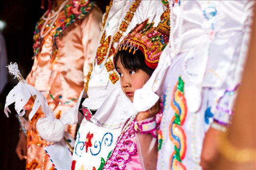 Her eyes tell the story. The awakening fear of the unknown. Her head is adorned in jewels, and the photographer before her shoots flashes at her and her towering siblings. But she cannot relax. Feverishly she bows her head and dreams of the year before, running through rice paddies and chasing after the newborn goats. Passing marbles to her friends, shouting after trekking tourists and remembering nights sat in the shadow of her mothers warmth. It would not be the same, this summer. The next day, her head would be shaved and she would enter the nunnery for several months. 