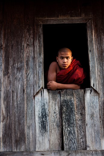 After the feasting, the child parading and buckets of tea drinking, sunset brings the villages to the local monastery. Built with local teak wood, it's brown façade is fading, but beautifully and elegantly. The inside creeks with every footstep of my heavy trekking boots. But the barefoot monks  pass without a sound. As gentle as their faces, they follow me to an upstairs window. Below sees a parade of novices, local children in their best jewels, on hired horses, and surrounded by uncles and cousins playing sheep skin drums. The spectacle seems too brash for the simplicity of the Buddha's way, but it's only for a day. Tomorrow the children will learn serenity, and how to walk with silent feet through the teak monasteries.