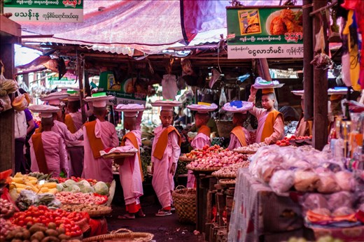 Days after the festival, I often spotted groups of young novices around the towns and villages of the Shan. I found one young boy, clearly not adapting too well to Buddhist teachings, shooting pellets his fellow novices with a plastic gun. The boys are often seen running along railway tracks or playing football in empty fields, their red robes already tattered at the edges. But the nuns always remain a calmness and a discipline about them. This was taken in the Pyin Oo Lwin market. The line of young girls seeped in and out of the vegetable stalls, accepting alms from market stall owners. Dusty pink robed and bare foot, looking confident in their new identity just days after it was given to them.  