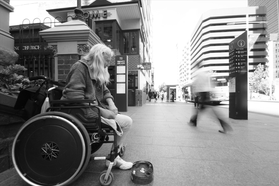 On the flip side of street life, a one-legged woman sits in silence on St. Georges Terrace in the Perth CBD. A regular around the Perth CBD, she waits for a few more charitable souls to drop coins before moving to another spot as the crowd of professionals thins after lunchbreak. 