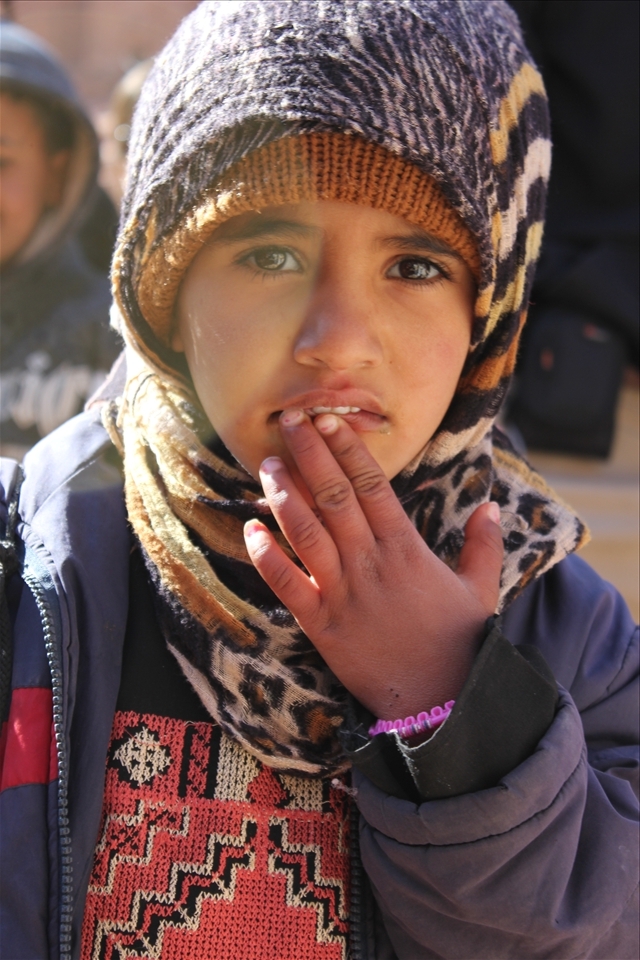 A five year-old girl turned my way, she was one of many children selling postcards to tourists.  Ten postcards for one American dollar.  

(unedited.)