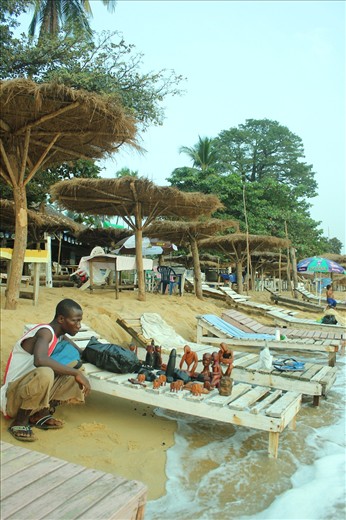 Alfa Kargbo jumps to save his crafts from waves that now reach the bars.
