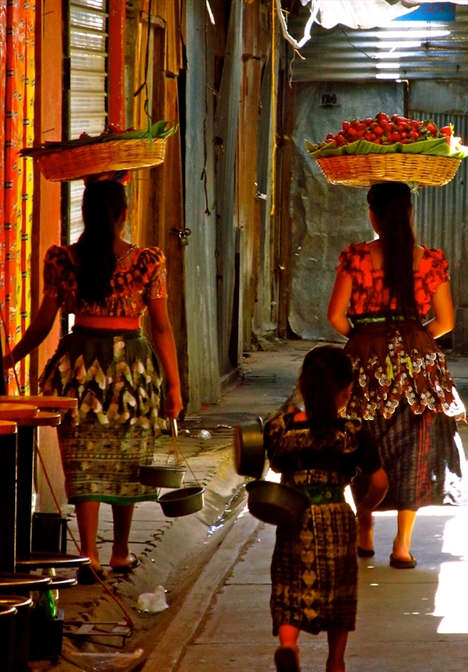 Any traveller can appreciate the sights, smells and sounds of the local market. In this particular one, I was unfortunately too slow to snap a child playing inside a bucket of rice with his toy before his mother grabbed him and sold a customer a bag of it! However I loved this shot of the 3 girls on their way out of the market with their purchases. It amazed me the strength the women had to balance the huge baskets of goods on their head without a single complaint. Their companion, matching in her huipals, was trailing after them, dragging her bucket and singing to herself as they left the bustling market.