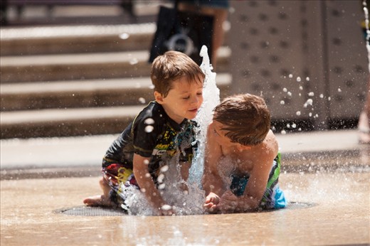 Children were having fun with the water fountains in the streets of Glenleg Beach area, Adelaide.