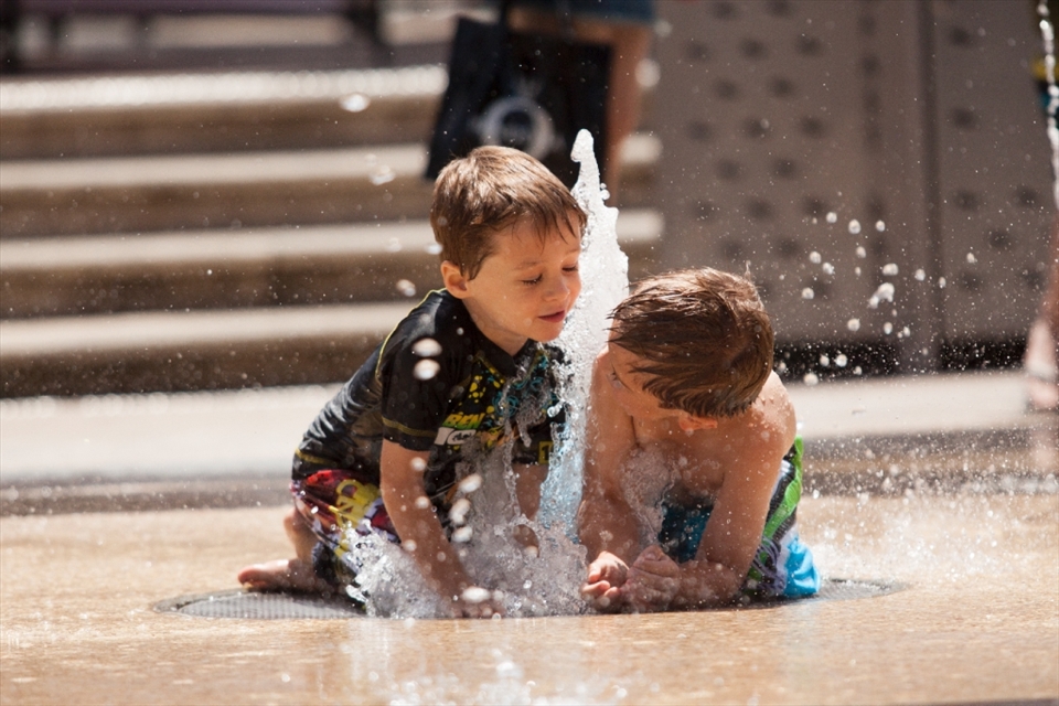 Children were having fun with the water fountains in the streets of Glenleg Beach area, Adelaide.