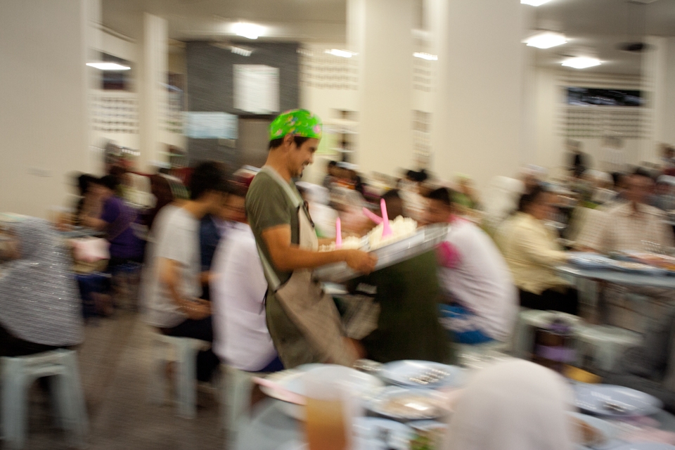 A mosque caretaker distributes foods during iftar (fast breaking). It is a local Moslem culture to serve foods during Magrib for anybody who comes. Using the money from donation, the mosque caretakers prepare tables around the mosque and cook those foods by themself. 