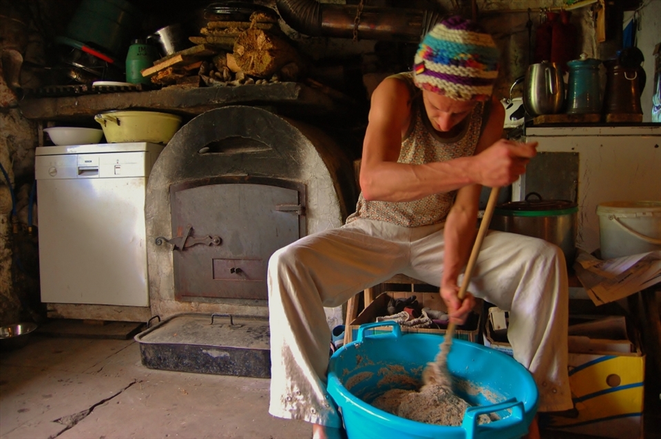 Till mixes the dough for the bread. The amount of mixing is shared between whoever is present at the farm. It takes about 2 and a half hours to get a good consistency, all the while Bob Marley's 