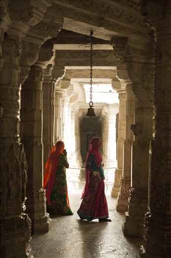 Women walk through a Jain temple built in 1439. Ranakpur, Rajasthan.