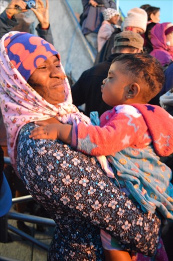 A grandma and a grand daughter are waiting until the sun rises. The little one one wants to play with grandma.