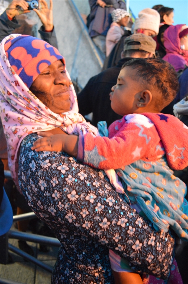 A grandma and a grand daughter are waiting until the sun rises. The little one one wants to play with grandma.