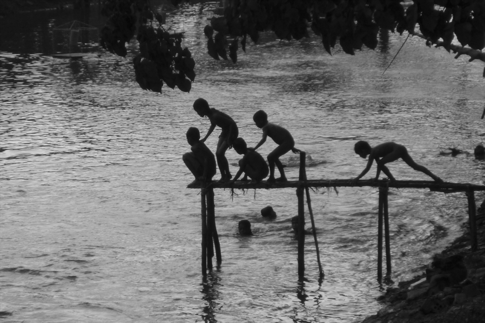 Local children play in the river, escaping the heat of the day.
