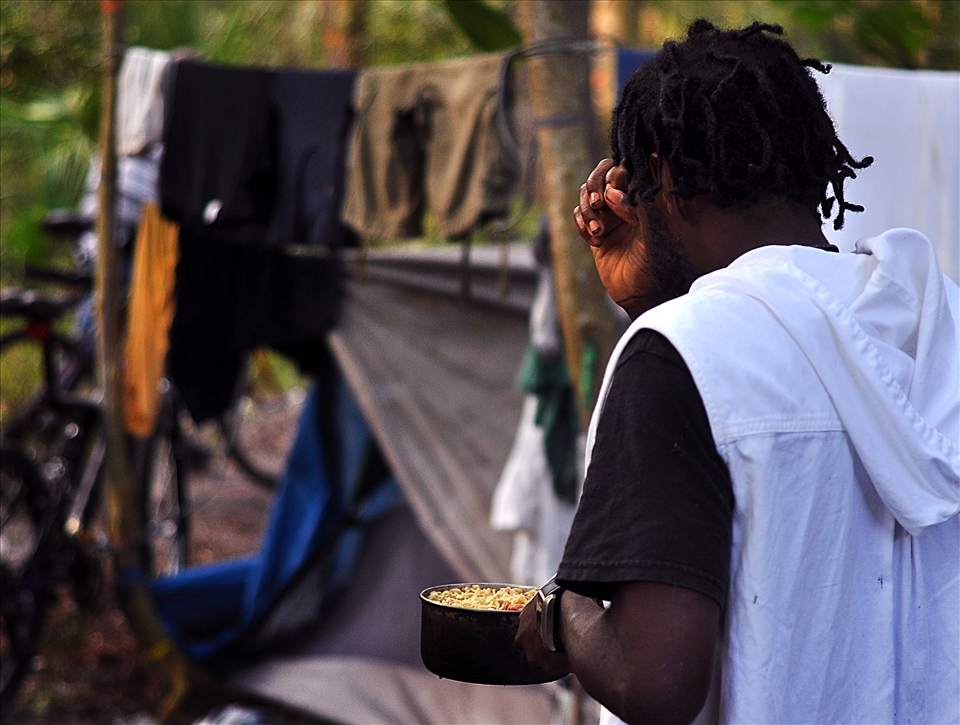A resident of the camp prays with blessings before his meal.