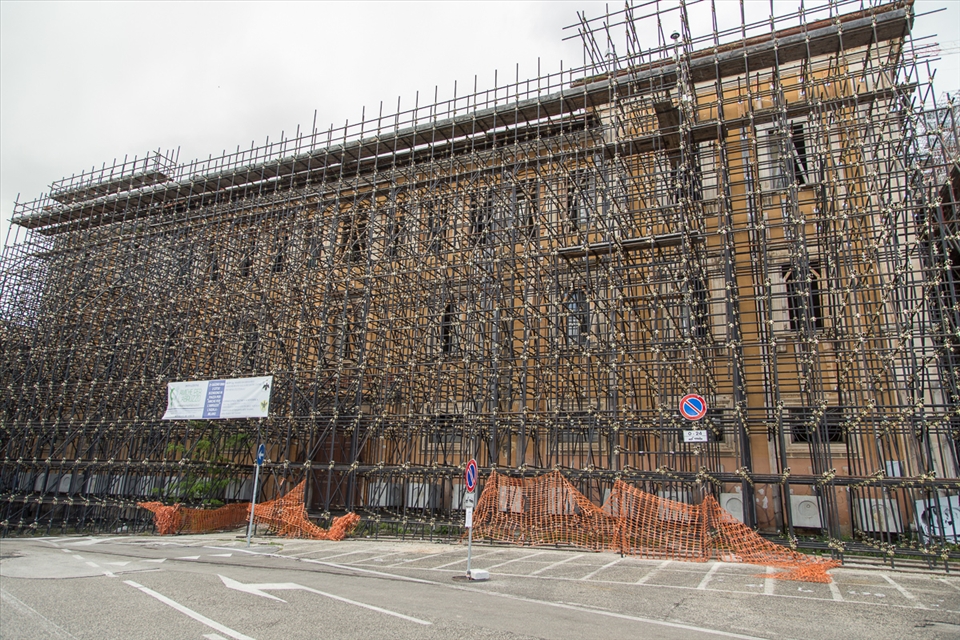 This image is of a residence apartment which is barely visible and completed covered with the Scaffolding to support the building and prevent it from collapsing. The Scaffolding's supporting the buildings is a very common scene in L'aquilla and you can hardly see a building without the Scaffolding.