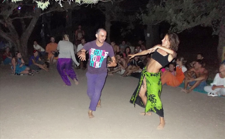 Couple performing contact improvisation at the festival “Love and light” in a forest camp of  Sarych headland of the southern coast of Crimea with the live music, performed by new friends