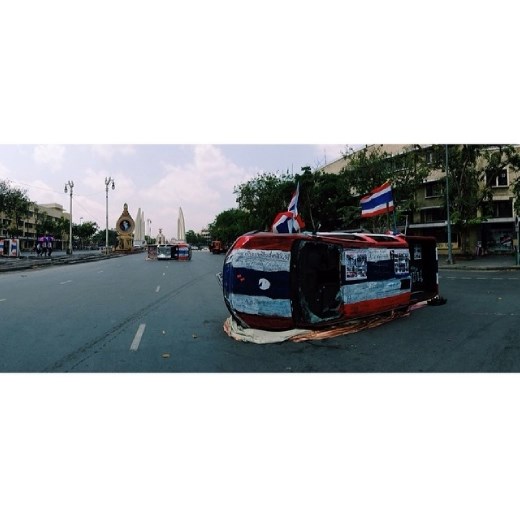 Via Instagram: panoramic view of a street demolished by protestors. The writing on the overturned police car reads 