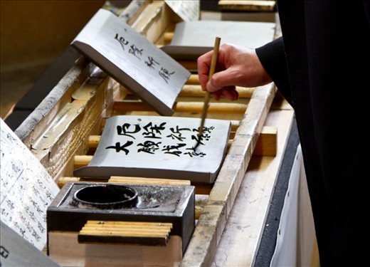 A local man completing his signed roof tile for the repair of the Great Buddha Hall at Todai-Ji Temple, Nara.