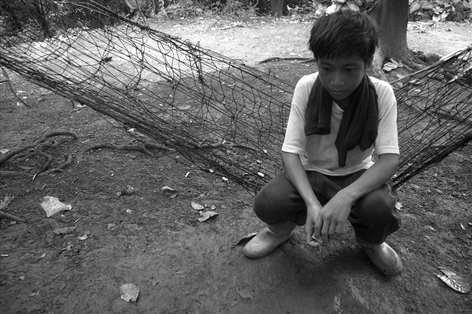 Edgar sits dazed on a makeshift hammock after a long day of work.  His father has fallen ill and is no longer able to work in the dumpsite. Since then, Edgar stopped going to school to help his mother earn a living. He dreams of becoming a seaman to lift his family out of poverty. 