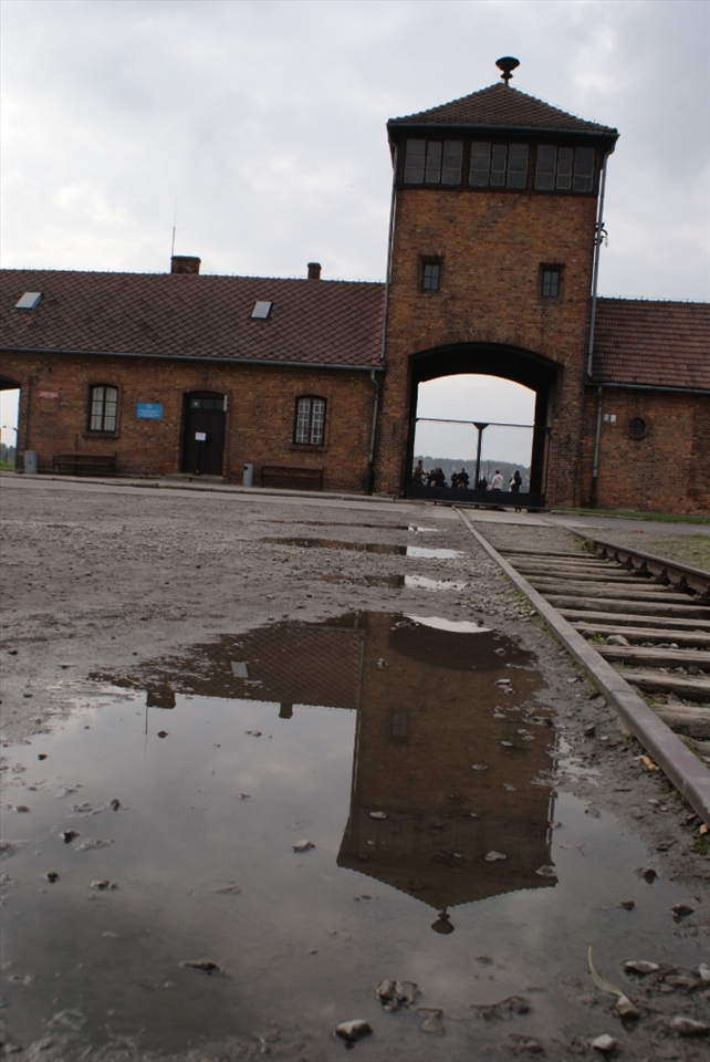 The famous gate threatens to swallow whatever approaches on the train tracks leading up to it. These were specifically built to bring deportees directly into the gated site.