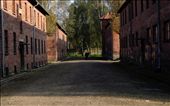 Between the buildings that used to house Nazi administrators and soldiers, a security guard is hit by a stroke of sunlight. He stands on the alley all of the prisoners had to pass before they were counted every day. Many of them for the last time before they were shot.: by auschwitz, Views[750]