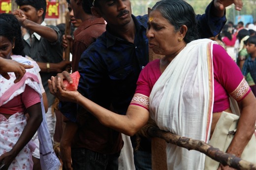 the pushes and rush to get food that is offered in return may be a tad aggressive but their pure willingness and sacrificing their well being for their believe is admirable. A great emotion captured of a women after all the tussle to get some watermelons.