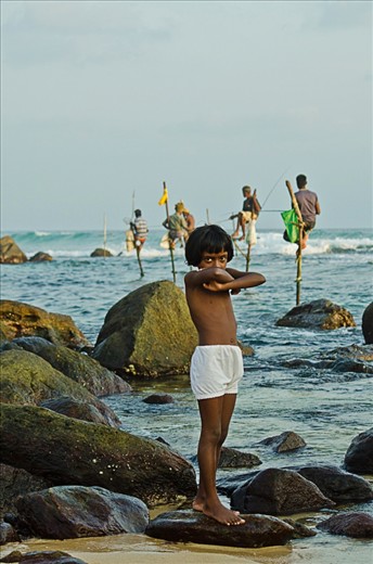 Young boy is waiting while the men are fishing.
Fishing in the island of Sri Lanka