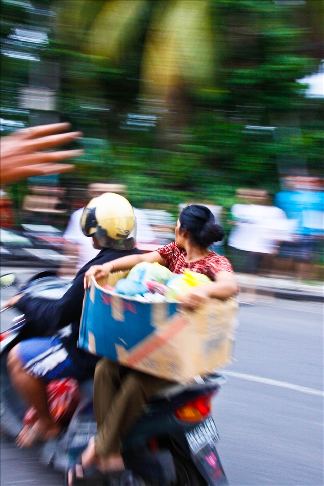 Down town Seminyak. - The Scooter is the transportation of choice in Bali, and it amazes me what people take on their scooters and how much they pile up on them. This lady was so relaxed sitting side saddle. 