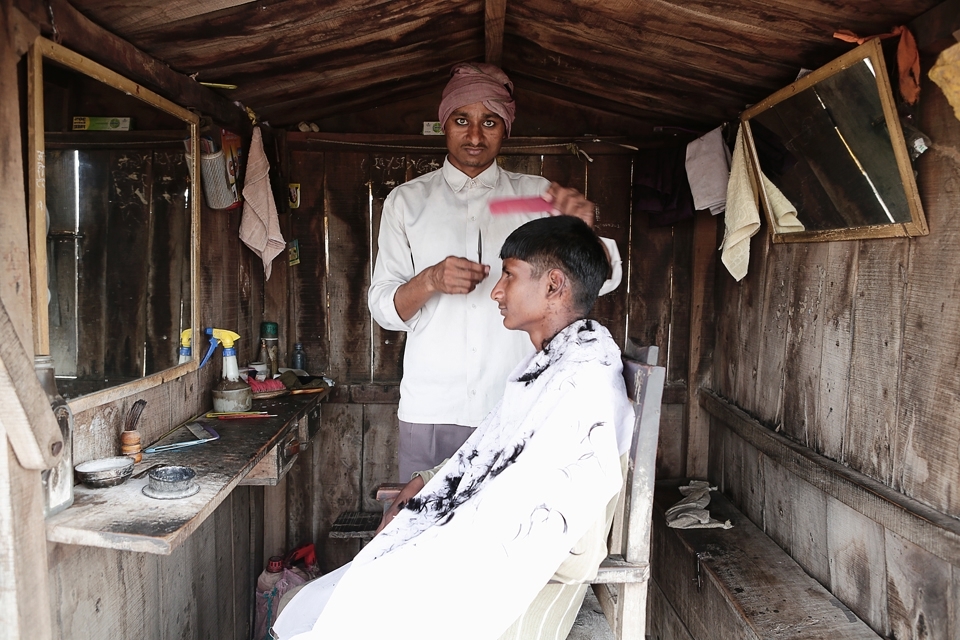 Rustic charm meets a brand new hair style as this barber grooms his subject with the precision of a surgeon. Huts like this are a common place for barbers and often a community of five or six barbers huts can be seen, with all the barbers sharing banter and trade between them.