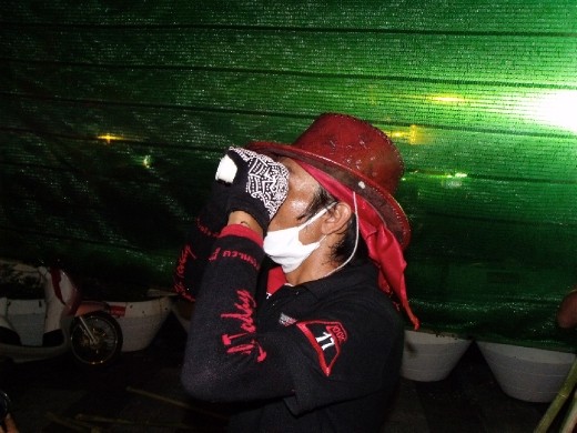 I was in Bangkok during the Red Shirt Protests a few years ago. This was taken at about 3:00 AM. The protester is watching the army set up in the monorail  station at the opposite side of the road.