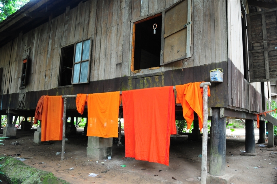 Orange robes dry outside the monk's dormitory. No washing machines or air conditioners here. The home built on stilts allows air to pass under the floorboards proving some relief from the oppressive heat. Siem Reap - Cambodia