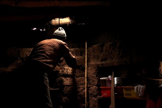 A local climbs his ladder to make sure the hole in his roof is big enough for the chimney we are about to build for him. 