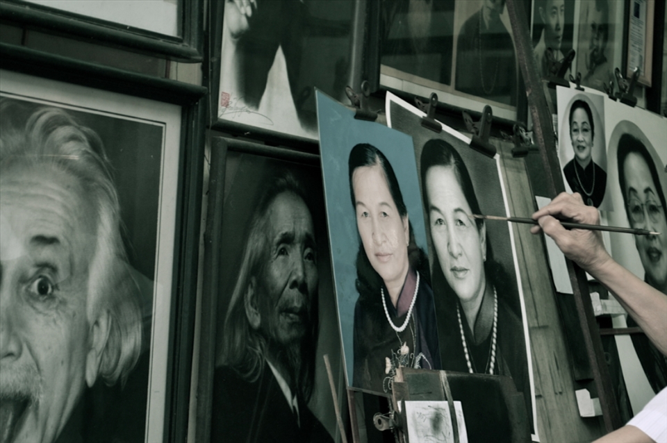 Seen at Hanoi, portrait artist in his small traditional gallery. 
