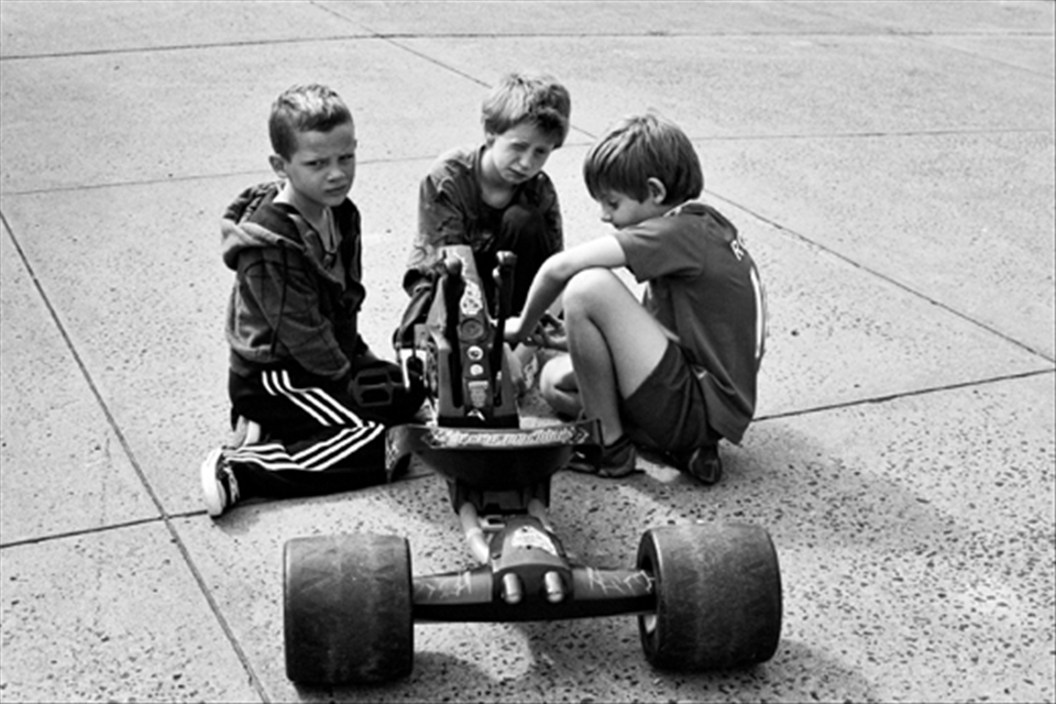 3 local kids trying to fix their broken trike which i repaired for them.