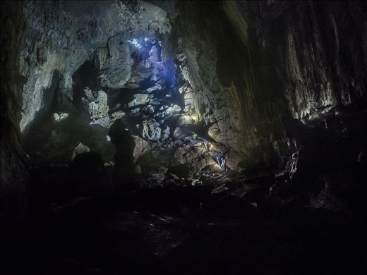 The gleaming rocks showcase a treasure chest of hidden natural wonder. The light from the entrance section is faint, itself being shrouded by boulders and forest. 